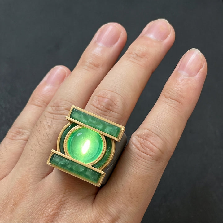 TV-style glowing green ring worn on a hand