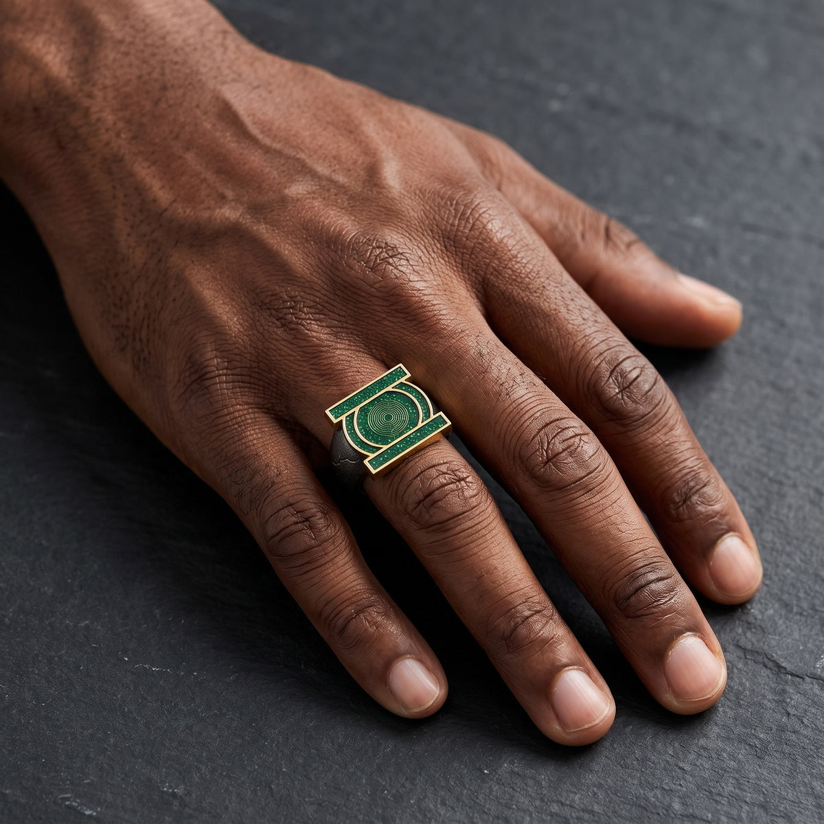 Green emblem copper open ring worn on a male hand with dark skin
